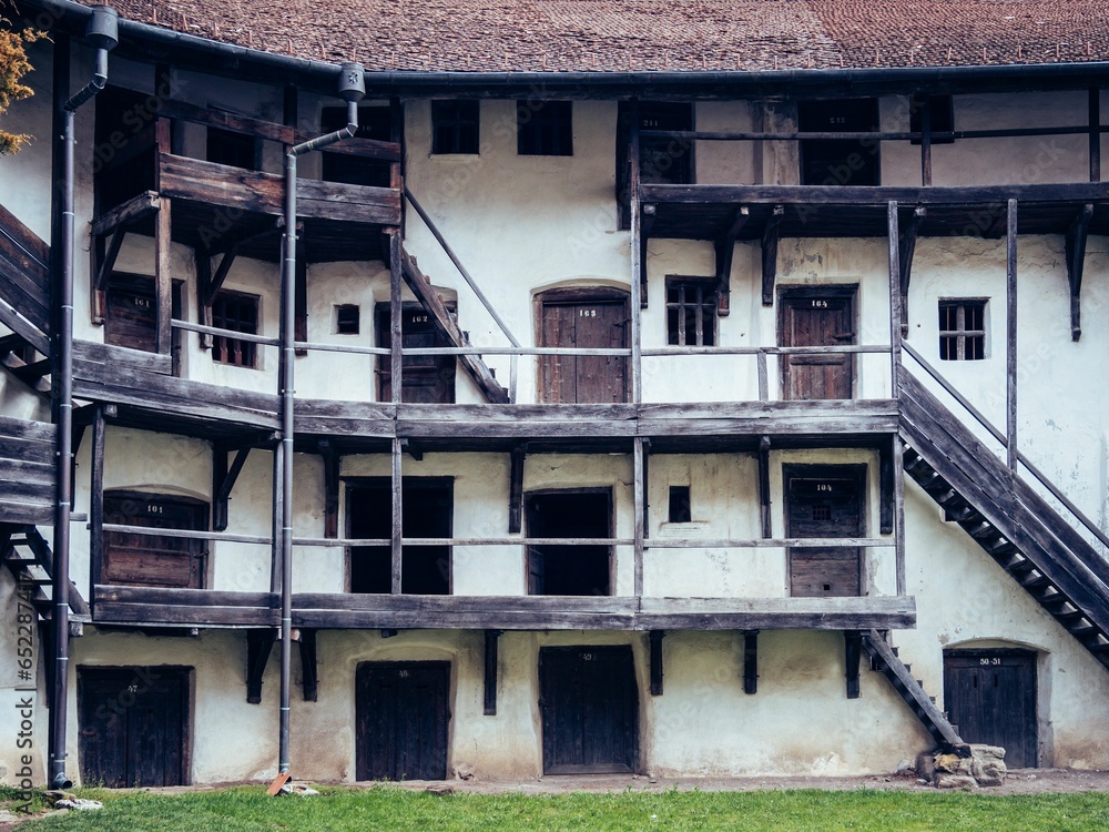 a very long building with wooden and metal stairs in front