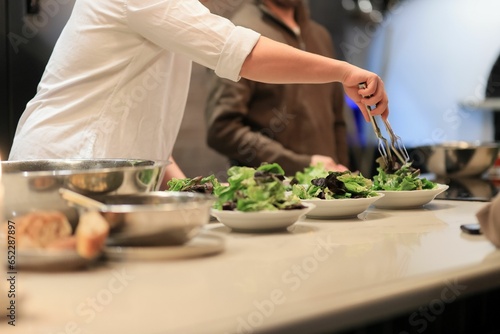 Chef preparing a healthy salad in a modern kitchen of the restaurant