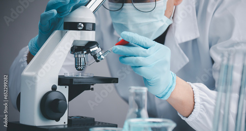 Medical Development Laboratory, biochemical research scientist Asian Doctor working with a microscope for vaccine development in the pharmaceutical research laboratory, Biotechnology Specialist