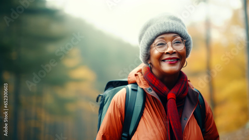 Healthy retirement lifestyle. Portrait of an elderly African American woman in the forest. Joyful beautiful retired woman traveling through the forest. Generated by AI © millenius