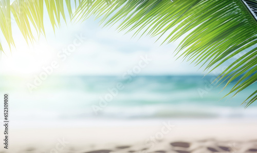 Close-up of palm leaf with blurred tropical beach. © Lidok_L