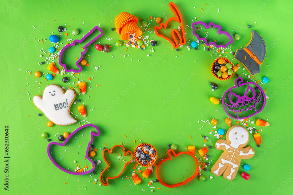 Bright colorful Halloween gingerbread cookies and sweet background. Homemade biscuits with cookie cutters, sugar sprinkles and candies. High-colored Halloween treats flat lay top view copy space Bright colorful Halloween gingerbread cookies and sweet background. Homemade biscuits with cookie cutters, sugar sprinkles and candies. High-colored Halloween treats flat lay top view copy space