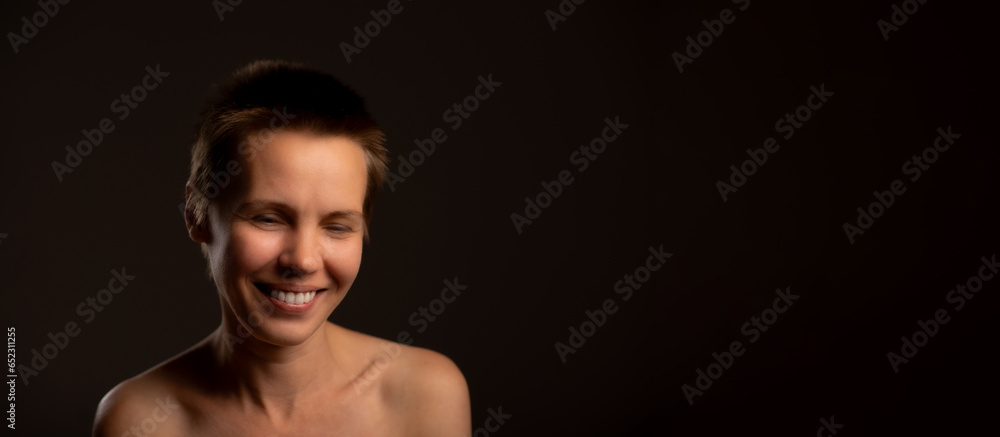 Middle-aged woman with chic short haircut, gracefully revealing her bare shoulders and subtle smile, set against sleek black backdrop. Encouraging self-care and skincare routines. Banner