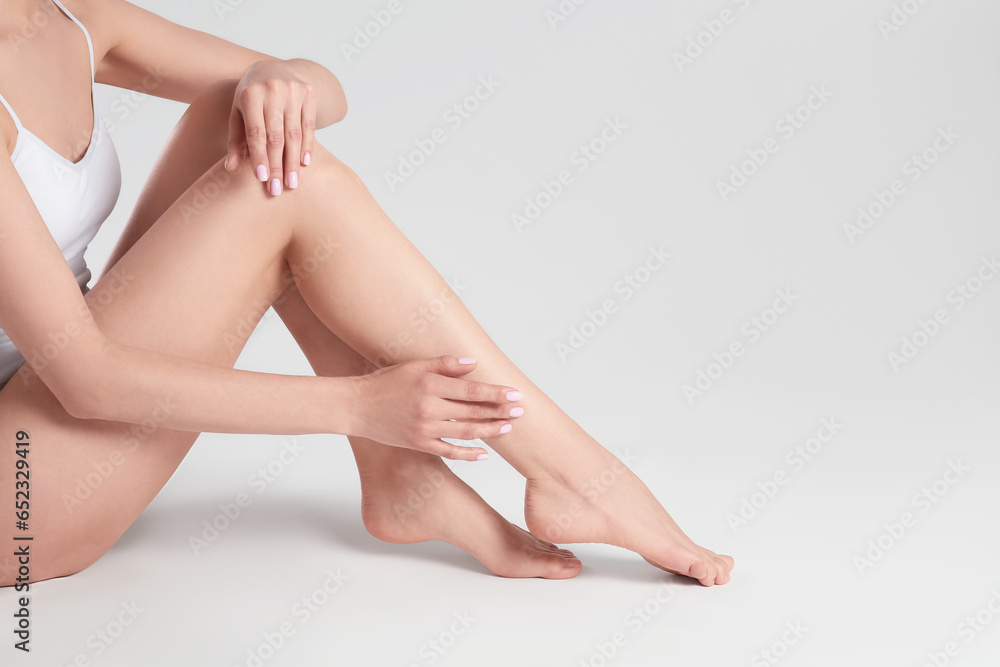 Woman with beautiful smooth legs on white background, closeup. Space for text Woman with beautiful smooth legs on white background, closeup. Space for text
