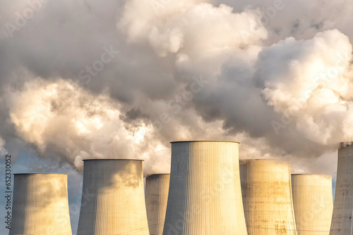 towers of a power plant with hughe exhaust clouds photo