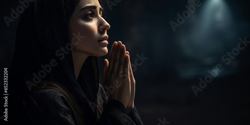 Side view of a woman praying at night, night mood with copy space