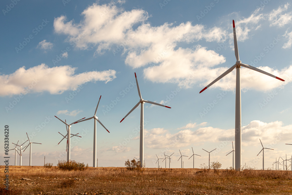 Wind turbine farm over the blue clouded sky Wind turbine farm over the blue clouded sky