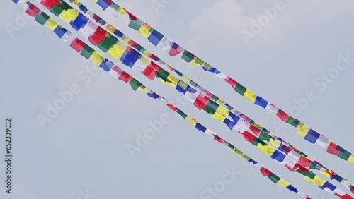 Prayer flags blowing by the wind in sacred place in rural Nepal. The prayer flags initiate peace and good tidings, their sacred mantras etched on the wind.