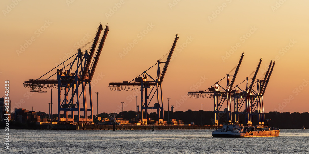Containerbrückem am Athabaska-Kai im Hamburger Hafen bei Sonnenuntergang mit einem kleinen Tanker. Containerbrückem am Athabaska-Kai im Hamburger Hafen bei Sonnenuntergang mit einem kleinen Tanker.