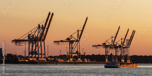 Containerbrückem am Athabaska-Kai im Hamburger Hafen bei Sonnenuntergang mit einem kleinen Tanker. photo