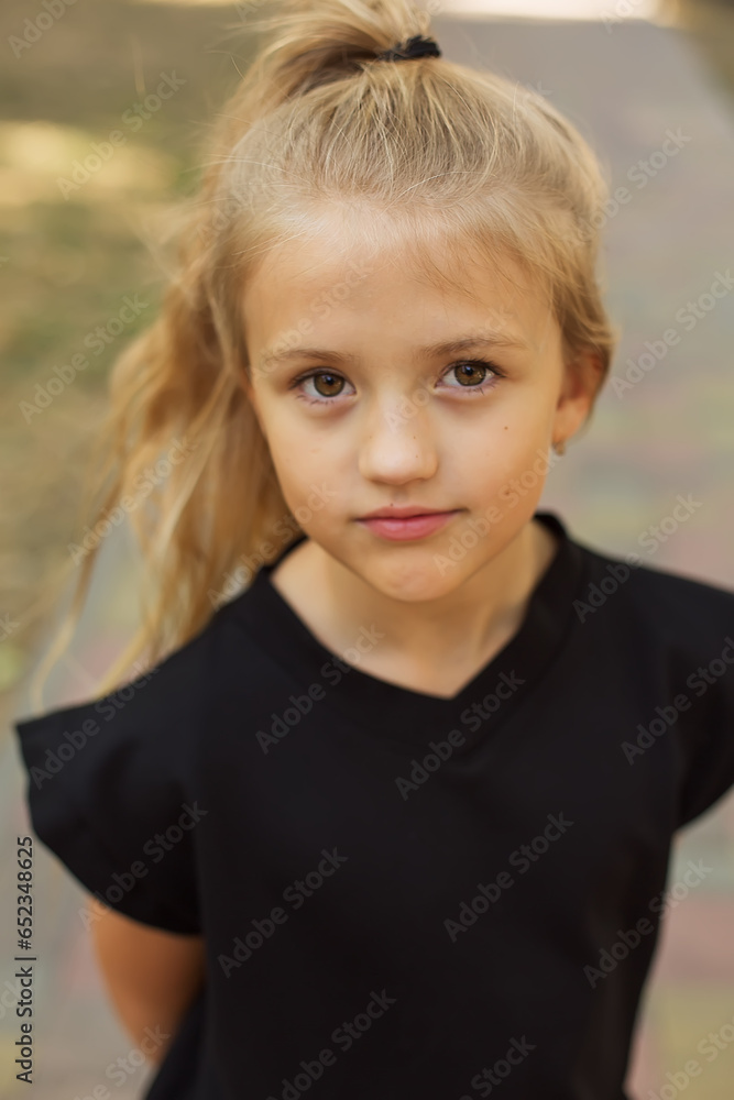 a large portrait of a blonde girl with big eyes and a ponytail in a black jacket a large portrait of a blonde girl with big eyes and a ponytail in a black jacket