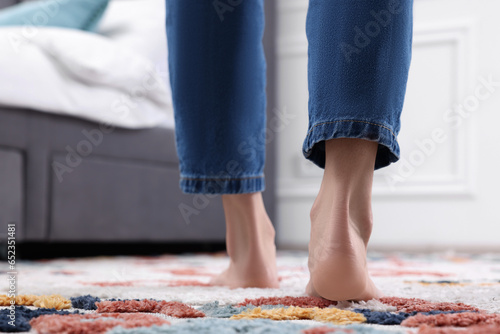 Woman walking on carpet with pattern at home, closeup