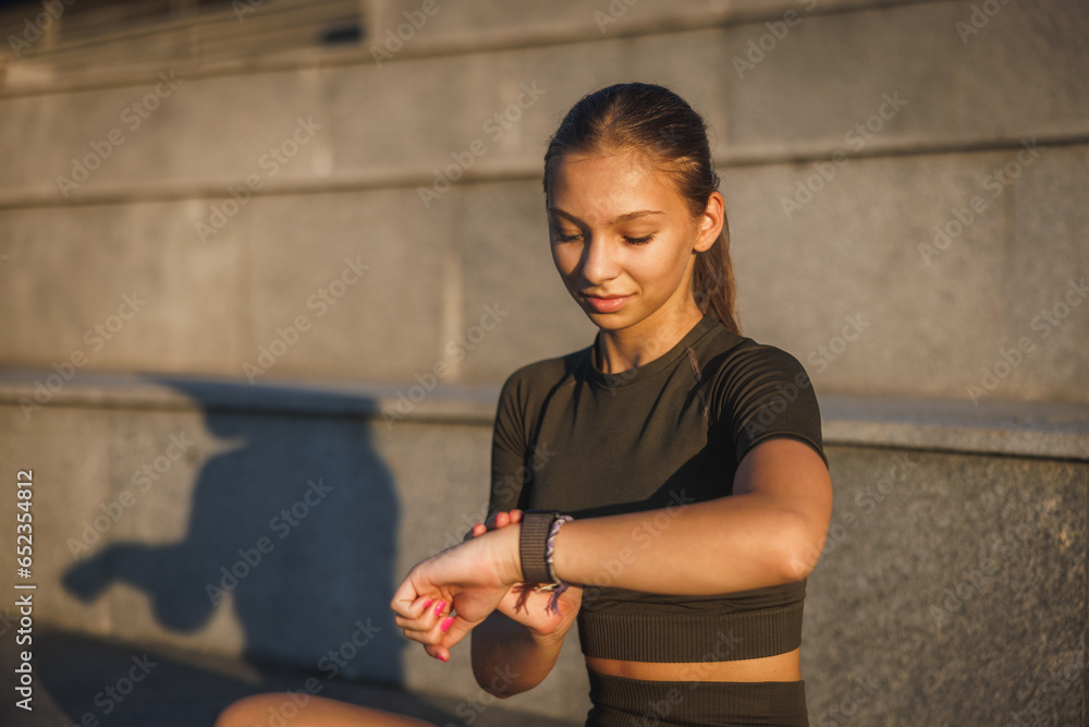 Teen Girl Looking On Smart Watch Before Training Outdoor