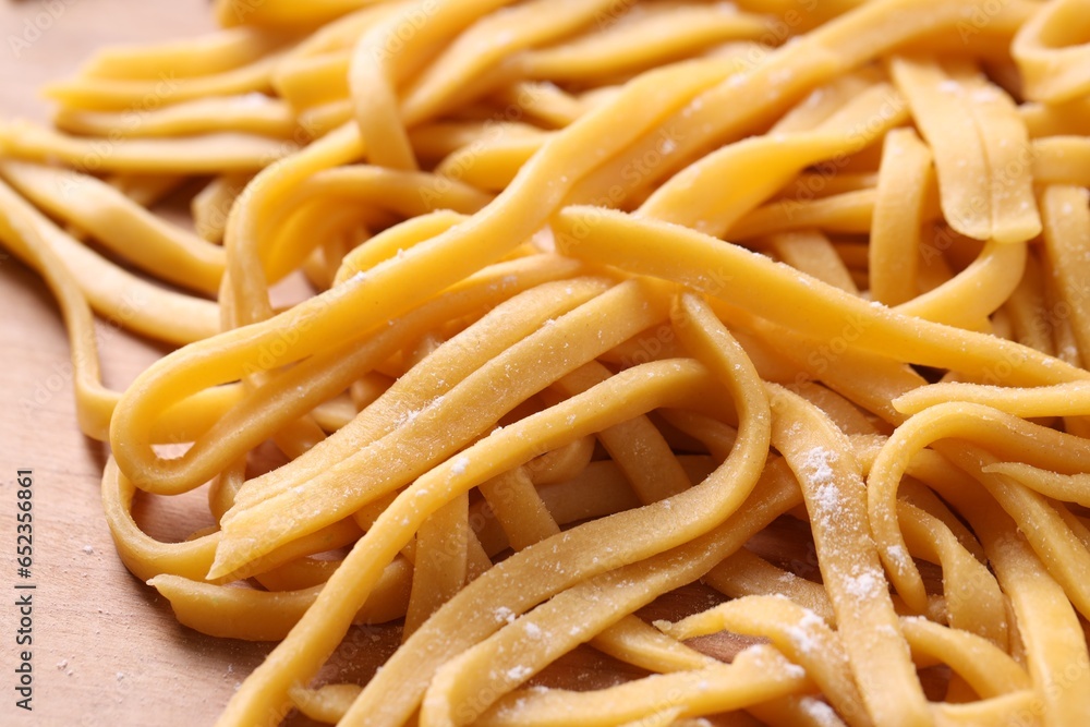 Raw homemade pasta on wooden table, closeup Raw homemade pasta on wooden table, closeup