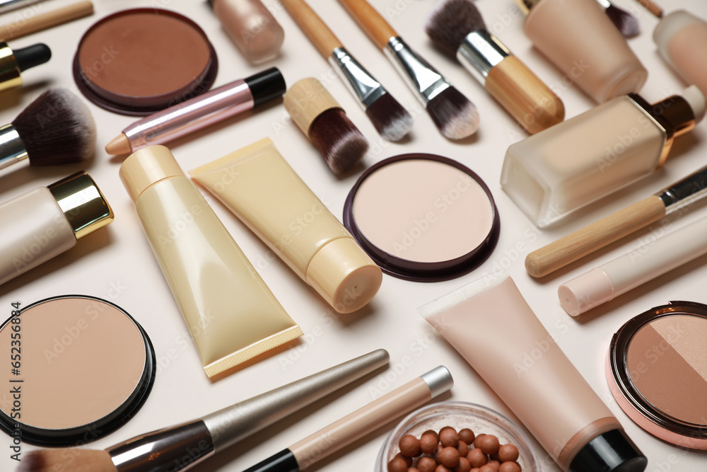 Face powders and other makeup products on beige background, closeup ...