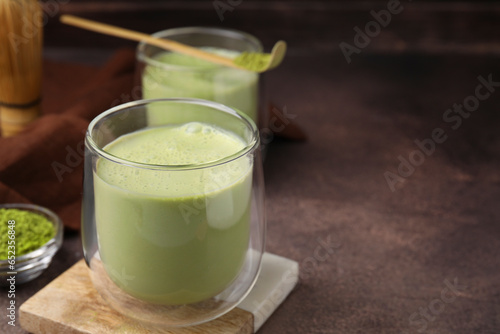 Glass of tasty matcha smoothie on brown table, closeup. Space for text