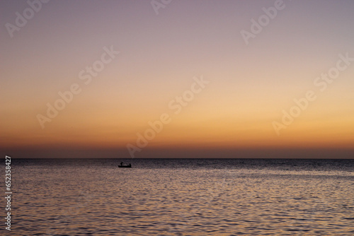 sunset on the beach with a fishing boat © Ryadh