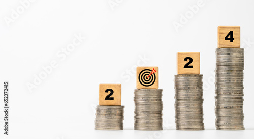 2024 with dartboard arrow on coins stacking of white background for setup enhance financial objective target and business profit investment goal in new year concept. photo