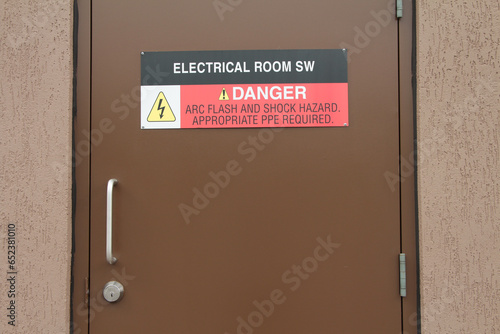 electrical room sw danger arc flash and shock hazard appropriate ppe required sign on brown metal entrance door with handle