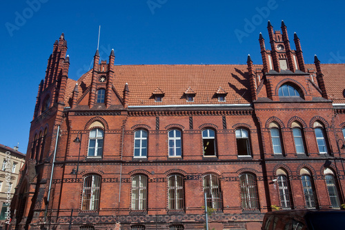 Zabytkowy budynek poczty zbudowany w stylu neogotyckim, z elewacją frontową o wielu sterczynach oraz wmurowanym zegarem, Grudziądz, Poland