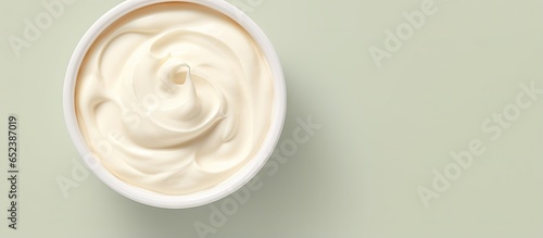 A isolated pastel background Copy space showcases a bowl of sour cream from above