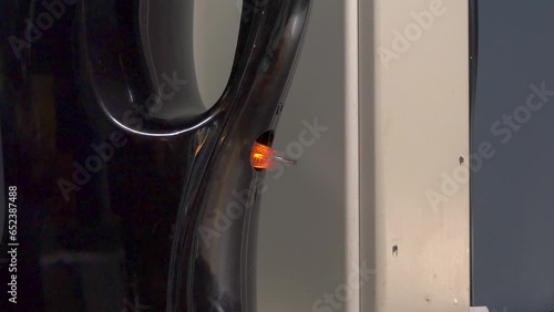 Hand turns on the electric kettle button. Close-up. Orange indicator light turns on.