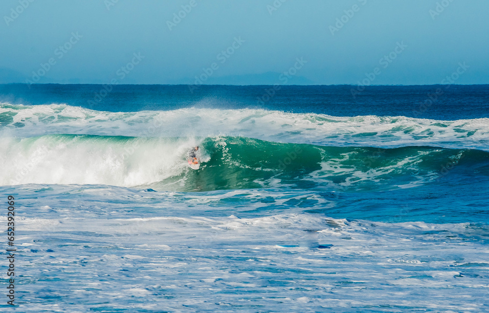 Fototapeta premium Surfer in a barrel falling under the force of the waves