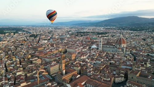 Colorful hot air balloon epic flying above Florence at sunrise, Palazzo Vecchio, Cathedral of Saint Mary of the Flower, Tuscany, Italy