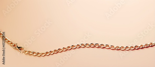 A isolated pastel background Copy space showcases a chain necklace made of gold jewelry