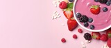 A delectable and healthy pink berry smoothie in a bowl seen from above against a isolated pastel background Copy space