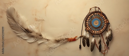 Native American spiritual symbol on circular object with leather beads feathers on a isolated pastel background Copy space