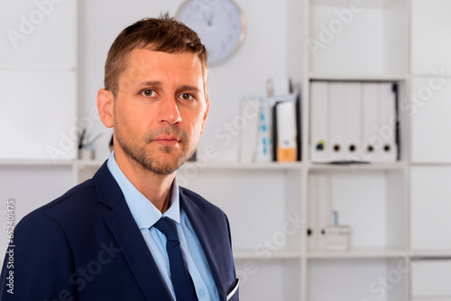 Male accountant in blue shirt suit and navy tie in office