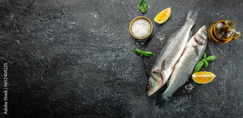 фотографія Fresh raw seabass fish on a dark background, Long banner format