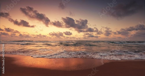Tropical ocean sunrise over beach shore and waves. The sun is rising up over sea horizon 4K video