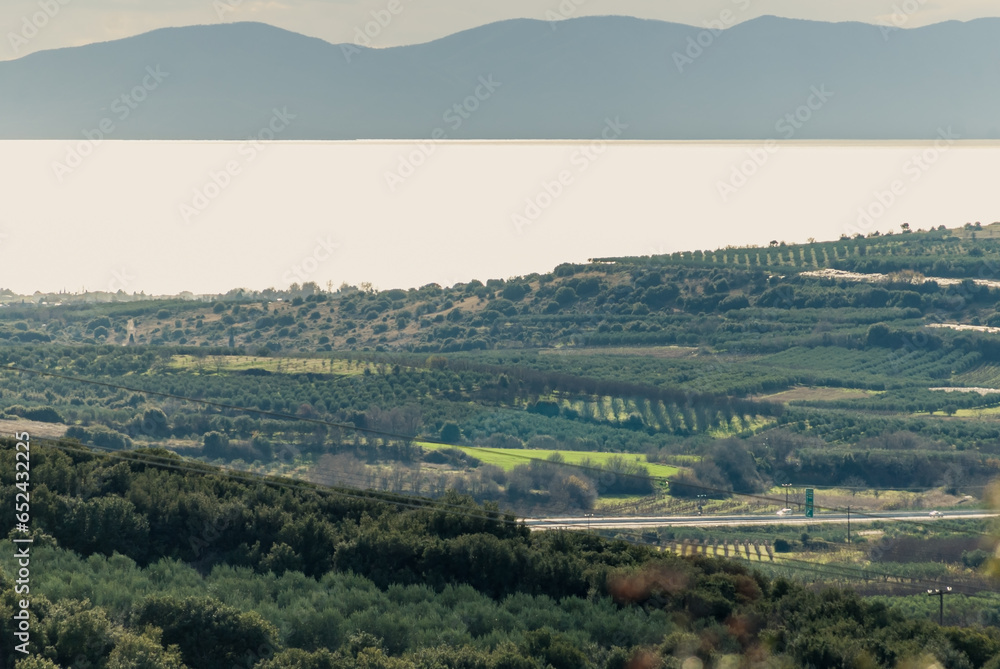 Panoramic view of farmland by the sea and the mountains beyond