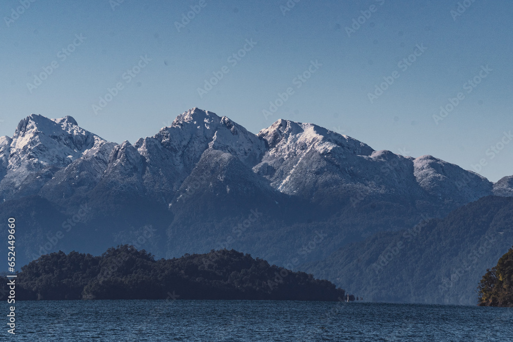 snow covered mountains by the lake in southern chile