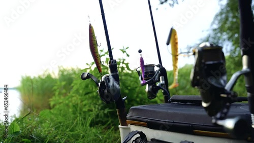 background video. The fisherman is preparing for fishing. He puts the boat on the water, prepared gear - fishing rods with wobblers. Moving the camera from the fisherman to the fishing gear. photo