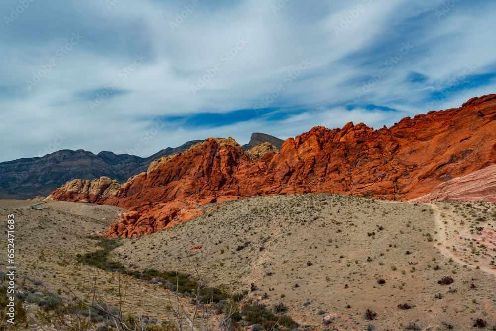 red rock canyon and mountains with a cloudy sky