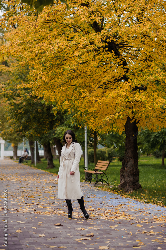 Girl in a white coat in an autumn park Girl in a white coat in an autumn park