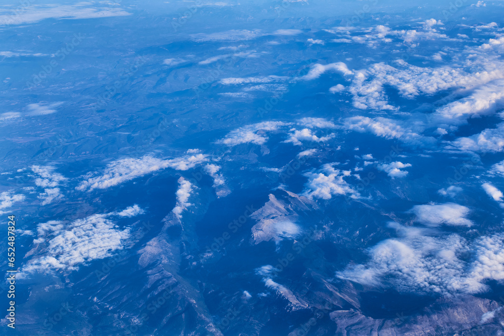 Mountain peaks seen through the clouds from the plane