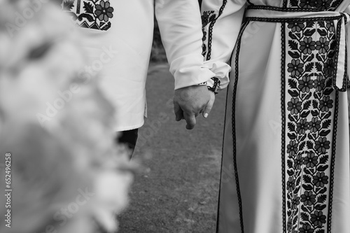 black and white classic photo, close-up view of a young couple holding hands in embroidered traditional Ukrainian clothes