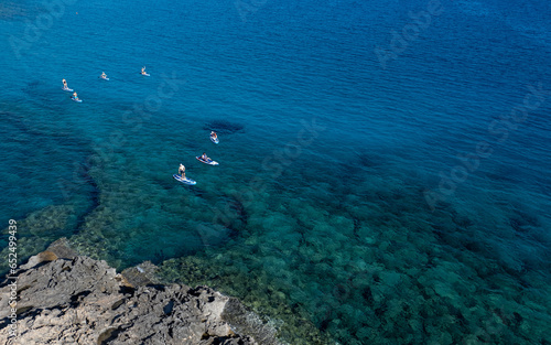 Done view of unrecognized people kayaking in the sea. People active, healthy lifestyle. Cape Grego Cyprus