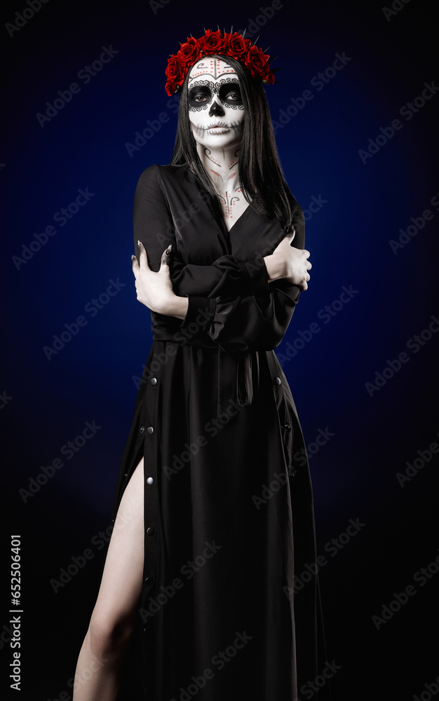 Young woman with calavera (sugar skull) makeup. The witch girl with muertos (muerte) greasepaint in black dress. Day of the dead (and Halloween) theme