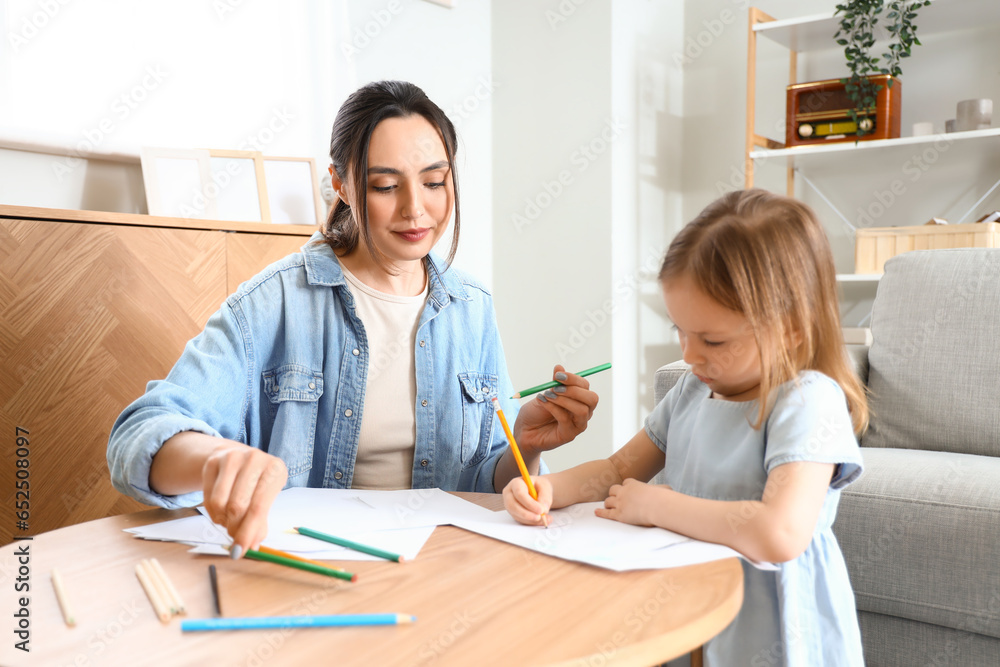 Young woman with her little daughter drawing at home Young woman with her little daughter drawing at home