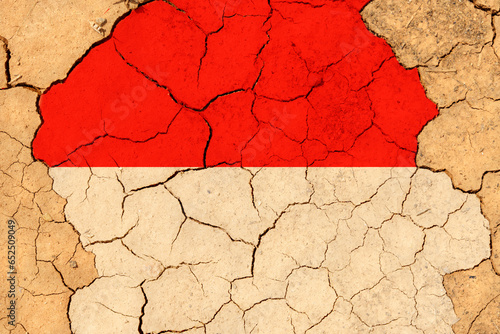Drought. On dry, cracked ground, the image of the flag of Indonesia.