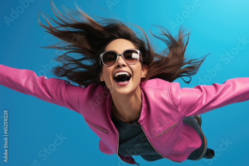 A woman wearing a pink jacket is captured in mid-air, defying gravity. This image can be used to portray freedom, adventure, and a sense of empowerment.