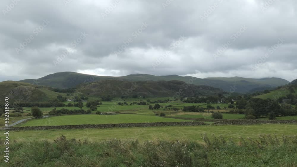 English farmlands by mountains on a cloudy day. English farmlands by mountains on a cloudy day.