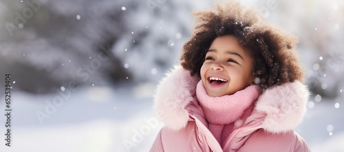 Happy Young African American Girl in a Pink Scarf in the Snow with Space for Copy
