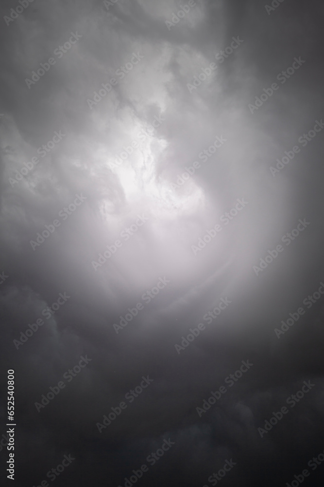Stormy sky cloudscape with a round bright vortex in the middle