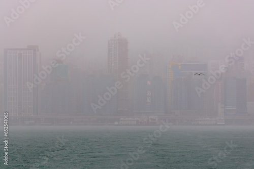 Fog and rain over modern high rise buildings in Hong Kong's Victoria Harbor